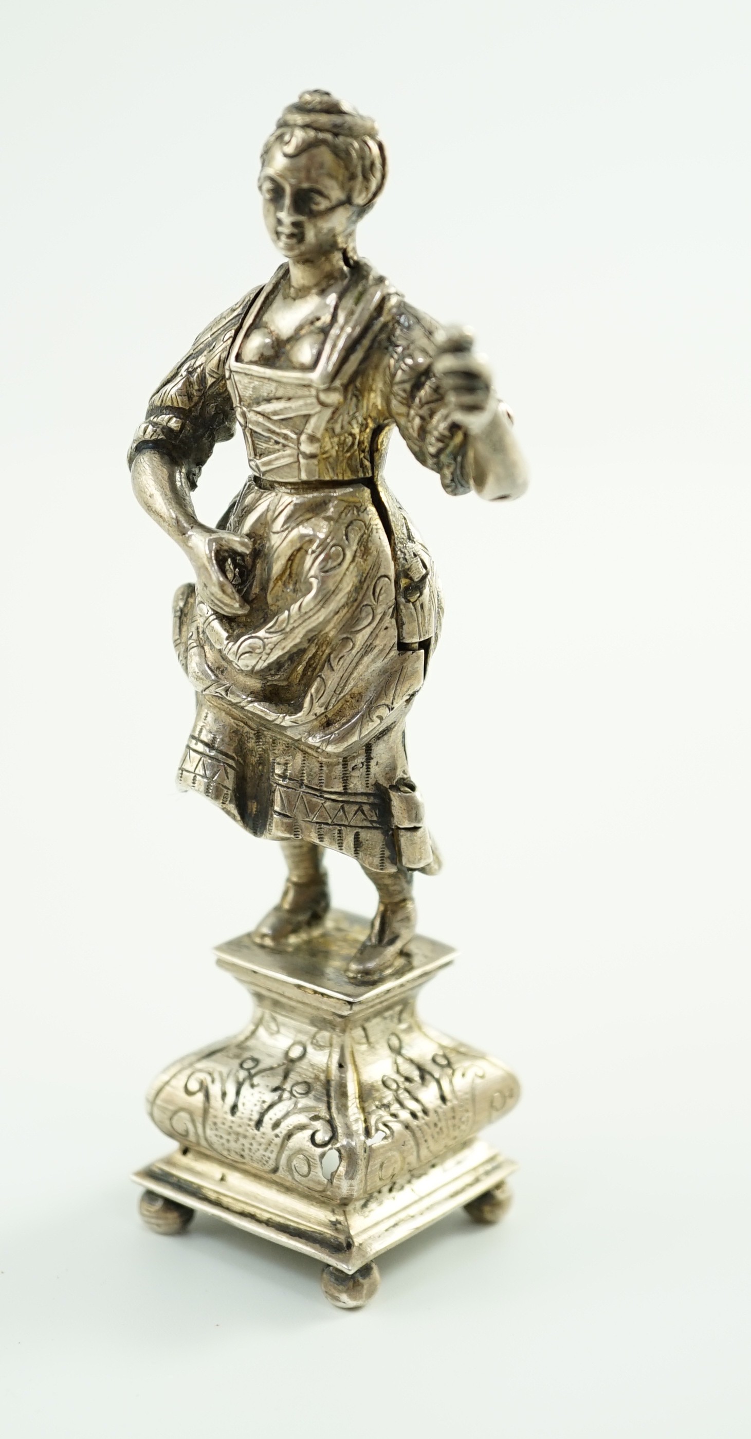 A late 19th century Dutch silver erotic miniature figure of a lady, on a square base with ball feet